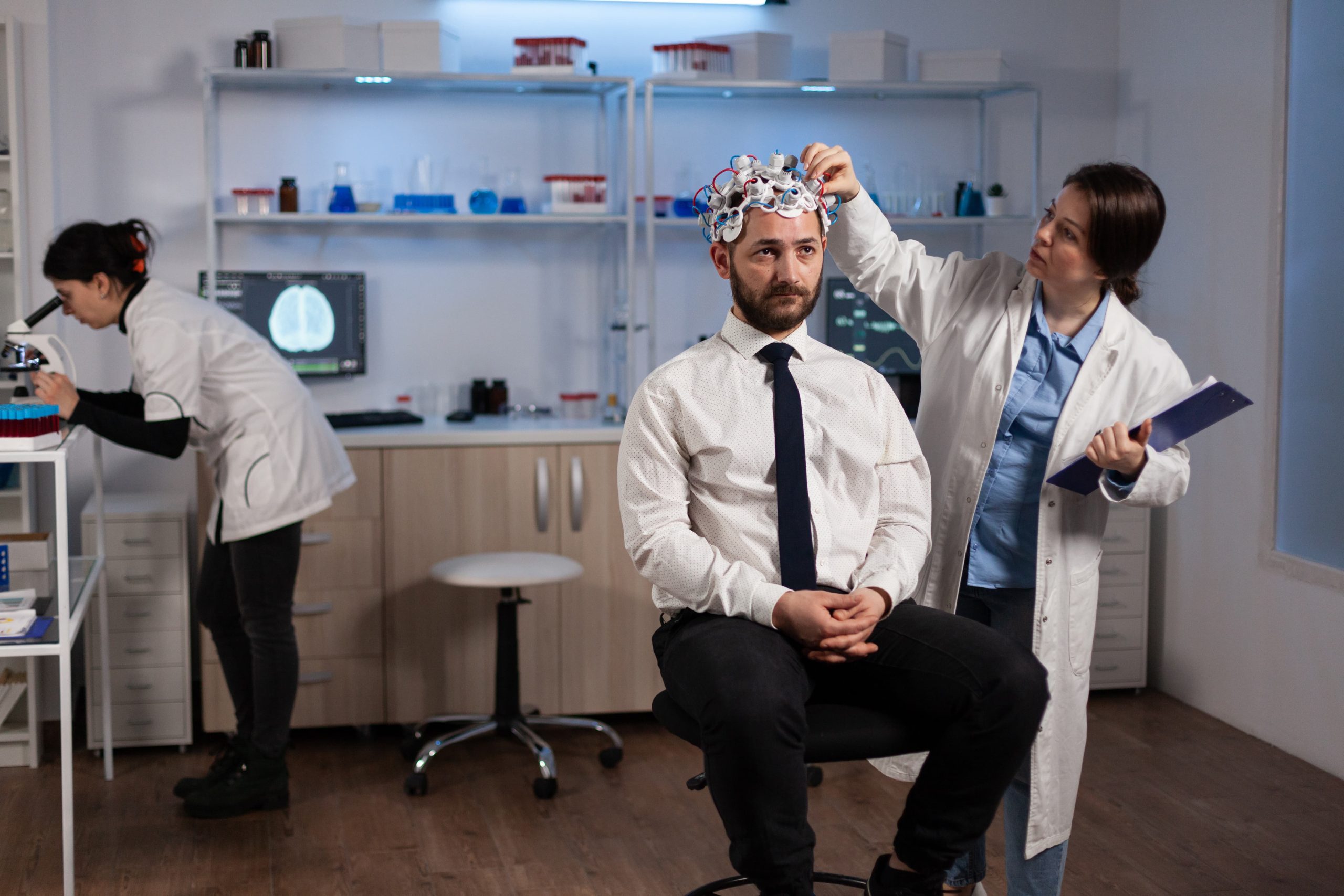 researcher-neurologist-woman-adjusting-eeg-headset-monitoring-brain-activity-man-patient-during-medical-experiment-modern-laboratory-scientist-doctor-analyzing-nervous-system-medicine-service